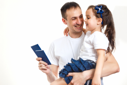 A father holding his daughter, his and a child passport. 