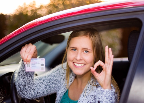 Woman holding a driver's license after the REAL ID Act.
